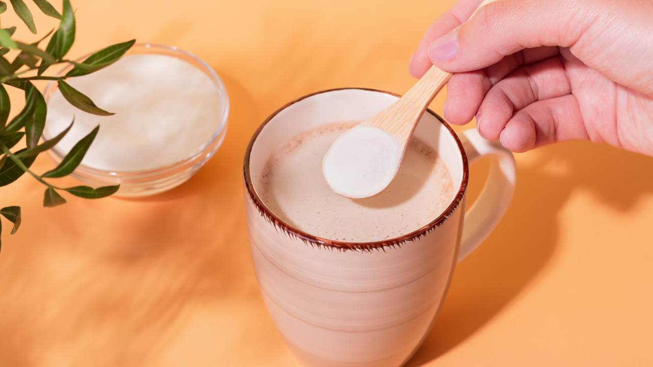 A person mixing collagen powder into a hot beverage.